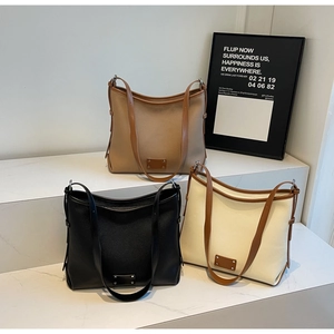 Three minimalist large tote bags in camel, black, and beige colors with lychee texture