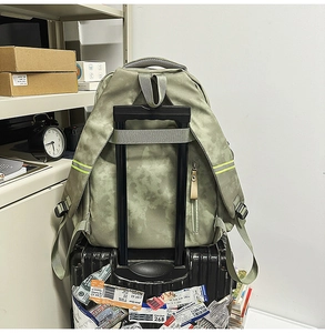 Détail du sac à dos camouflage vert mousse avec sangle de bagage et bande réfléchissante jaune