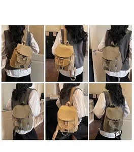 Detail view of khaki and green canvas backpacks with buckle closure on models