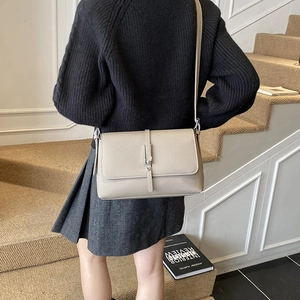 Detail of lychee pattern leather shoulder bag with vertical metal buckle and flap cover