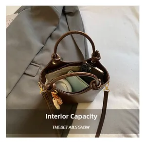 Detalle del interior de un bolso bucket marrón vintage que muestra su gran capacidad diaria