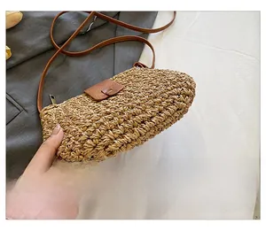 Detail view of woven straw shoulder bag with leather trim and reinforced base structure