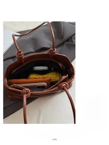 Interior view showing large capacity compartments and zipper pocket of the brown tote bag