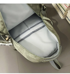 Détail de l'intérieur du sac à dos vert montrant le compartiment spacieux et poches