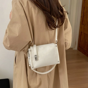Detailed back view of a white pleated shoulder bag with silver clasp on a model