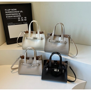 Detail of four-color fashion tote bags in black, gray, and beige with metal lock buckles