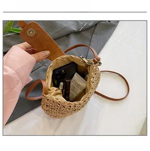 Detail showing internal capacity of the straw woven crossbody bag with daily essentials