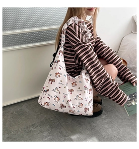 Close-up of pink tote bag with pony print and ruffled shoulder strap detail