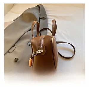 Detail of high-quality zipper hardware and leather texture on a brown square handbag