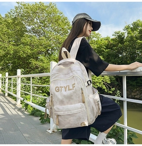 Détail du sac à dos beige grande capacité avec broderie GTYLF et multiples poches zippées