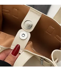 Close-up of the silver magnetic clasp and lychee pattern leather on this tote bag