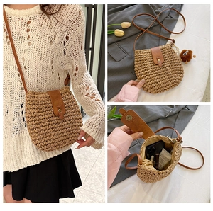 Detail view of woven straw crossbody bag showing internal capacity and leather strap
