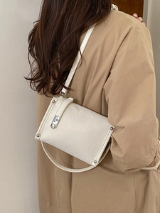 Chic cream pillow crossbody bag with pleated texture and silver hardware shown on model