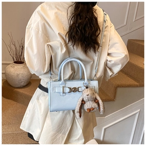 Détail d'un sac carré en cuir PU bleu clair avec un charm lapin en peluche amovible