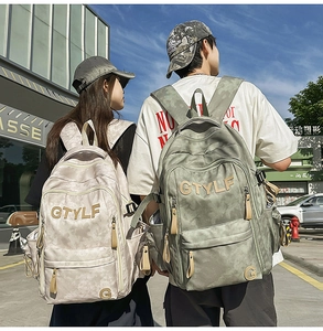 Détail de sacs à dos en toile camouflage avec broderie GTYLF dans une scène urbaine