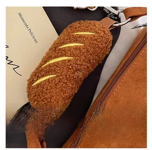 Macro view of brown plush bag handle cover with yellow embroidery and leather clasp detail