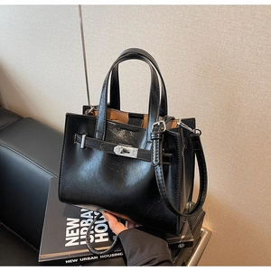 Macro detail of high-quality black faux leather bag with elegant silver metallic buckle
