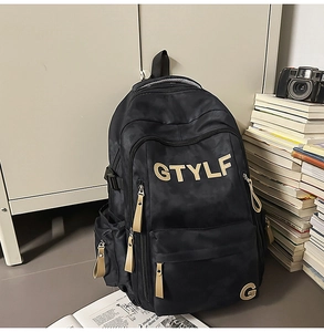 Détail d'un sac à dos noir avec texture camouflage et tirettes de fermeture éclair kaki