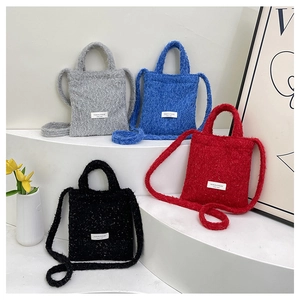Detail view of plush wool tote bags with textured finish and brand label in four colors