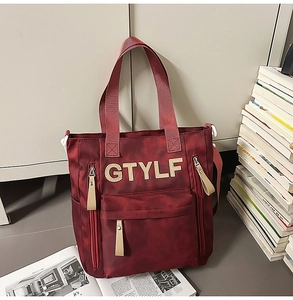 Détail du sac cabas bordeaux en toile avec poches zippées et imprimé logo GTYLF