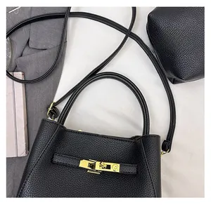 Detail of black lychee grain leather bucket bag with gold twist lock and interior space