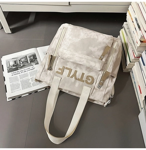 Détail du sac à dos en toile tie-dye gris avec logo G STYLE et fermetures éclair en métal