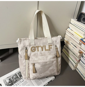 Détail du sac fourre-tout en toile avec lettres GTYLF 3D et poches zippées multiples