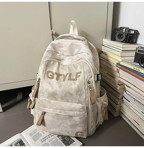 Vue détaillée du sac à dos scolaire beige avec broderie GTYLF marron et texture marbre