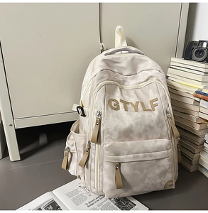 Détail du sac à dos camouflage crème avec broderie GTYLF et multiples poches de rangement