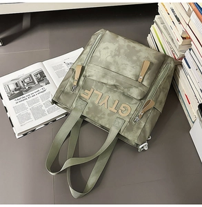 Détail d'un sac à dos camouflage vert olive avec patch STYLE et texture en toile