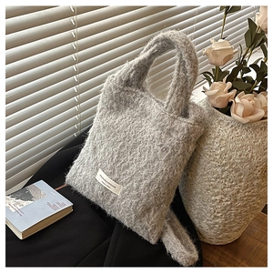 Close-up of gray fuzzy bucket bag showing thick wool texture and brand label