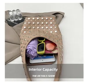 Macro view of beige rivet shoulder bag interior showing large storage capacity