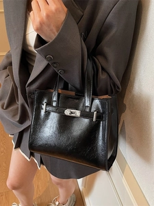 Classic black faux leather tote bag with twist-lock closure and elegant top handles