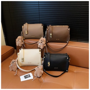 Chic荔枝grain square handbag set in four colors with cute bear charms on a leather sofa