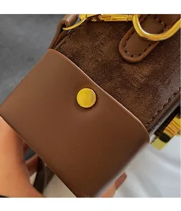 Detail of vintage brown patchwork bag featuring gold rivets and D-ring metal hardware