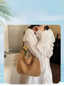 Detail of a large beige crochet tote bag with hollow lace pattern and tulip decor