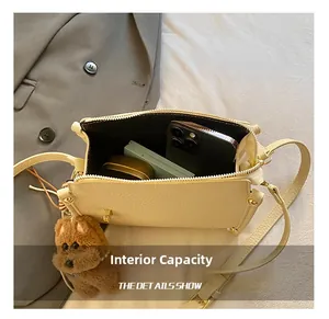 Interior view of beige pebble leather handbag showing phone and makeup storage space