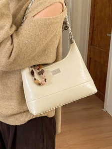 Minimalist beige quilted shoulder bag with silver chain and colorful bead charm