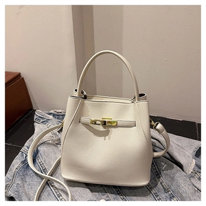 Detail of off-white bucket bag with lychee grain leather and golden metal twist lock
