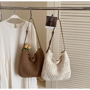 Dettaglio di borse tote all'uncinetto in marrone e beige con eleganti manici in pelle
