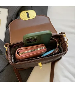 Detail shot of a brown vintage leather bag showing its spacious interior for phone and wallet