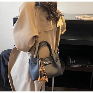 Détail du sac à main noir avec surpiqûres blanches et fermoir rotatif en métal argenté