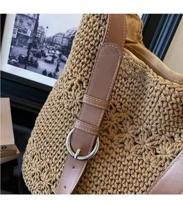 Dettaglio borsa tote in paglia all'uncinetto con tracolla in pelle e fibbia argento