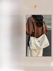Detail of white and pink travel bag showing wide straps, buckle, and drawstring closure