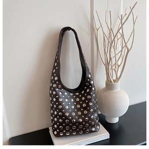 Close-up of deep brown leather hobo bag with silver rivet studs on white background