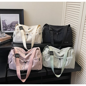 Waterproof nylon travel bags in four colors arranged on a minimalist display shelf