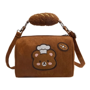 Brown plush cylindrical bag with a bear embroidery and fluffy bread charm on top
