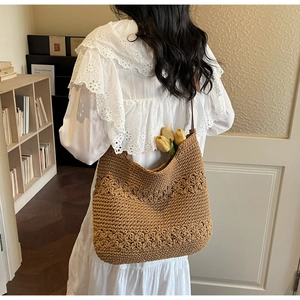 Detail of brown crochet tote bag featuring intricate floral hollow-out knit patterns