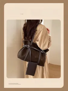 Detail of a large brown suede tote bag with contrast stitching and attached coin purse