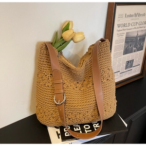 Detail of hand-woven floral patterns and adjustable brown leather strap on tote bag